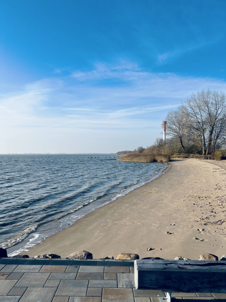 Ein Blick vom Ende der Promenade am Hafen in Kollmar aus auf den dortigen Leuchtturm – bei Flut, am Strand gut zu erkennen.