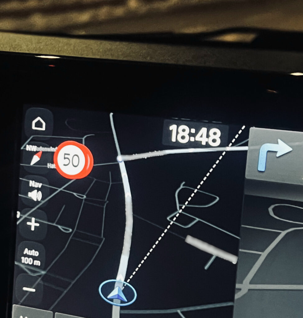Blick auf ein klassisches Navigationsgerät wie es in den Autos unserer Tage verbaut ist. Das Display zeigt neben der aktuellen Position auch an, dass demnächst rechts abgebogen werden soll und wie schnell gefahren werden kann.